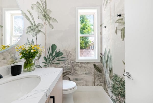 Bright modern bathroom with botanical wallpaper, sleek finishes, and natural light creating a serene oasis.