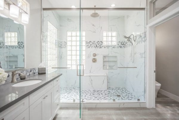Luxurious modern bathroom with walk-in shower, marble tiles, and elegant double vanity design.