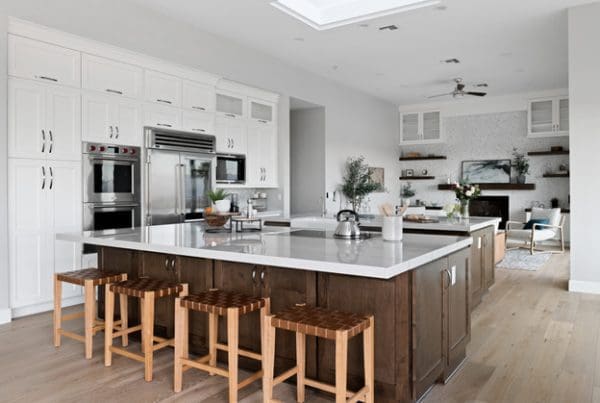 Modern spacious kitchen with white island, dark cabinets, and abundant natural light for inviting gatherings.