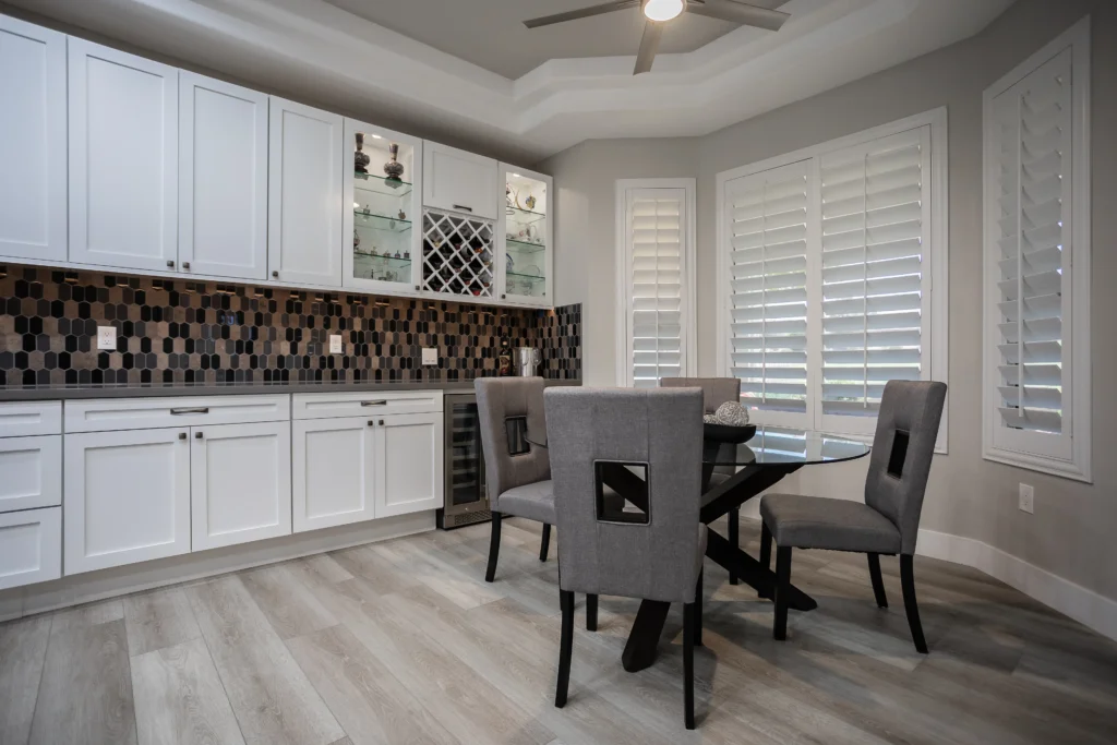 Elegant breakfast nook featuring white cabinetry, mosaic backsplash, and inviting round dining table.