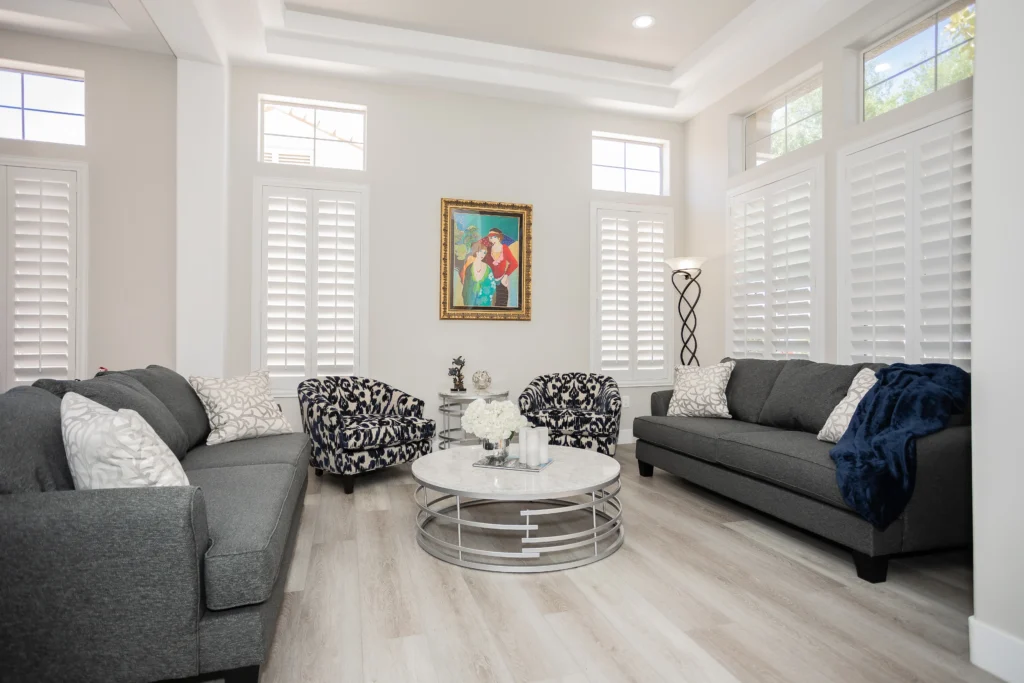 Bright modern living room with stylish décor, bold accents, and natural light from large windows.