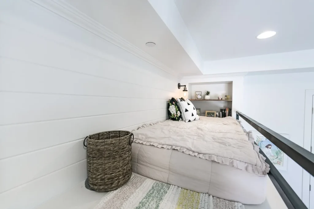 Cozy Loft Sleeping Nook by Reveal Interior Design Charming loft sleeping nook with bright decor, cozy bedding, and natural light for relaxation.