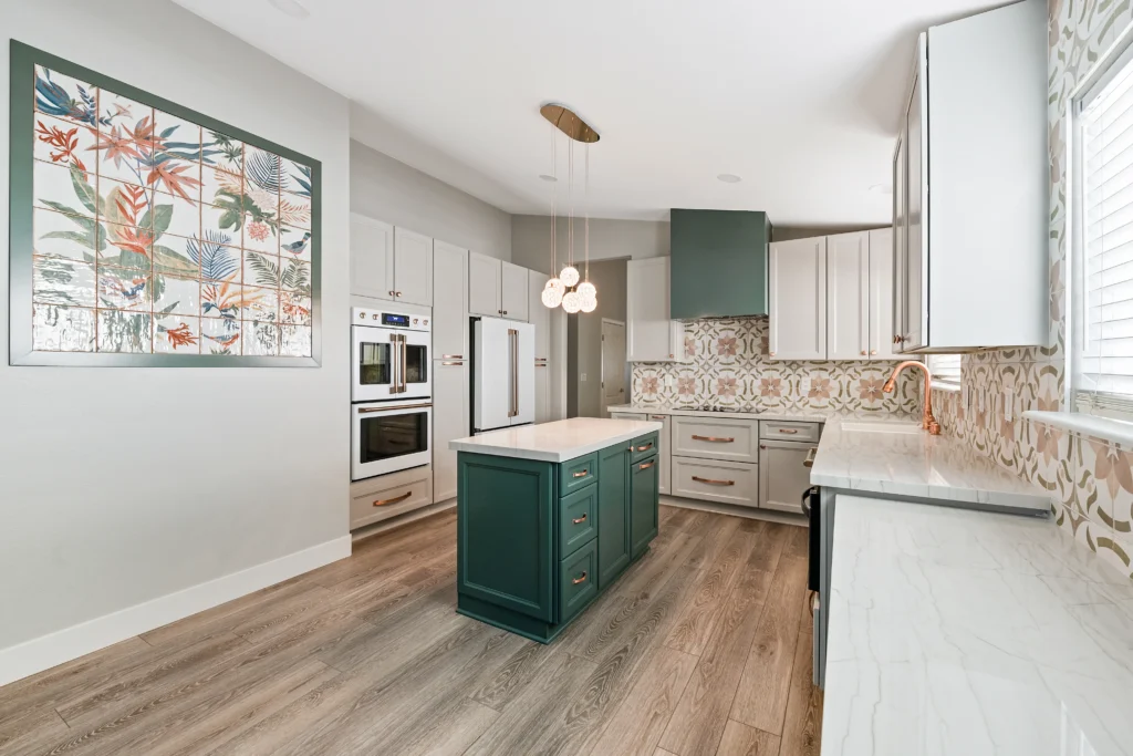 Stylish modern kitchen with deep teal island, vibrant backsplash, and ample natural light.