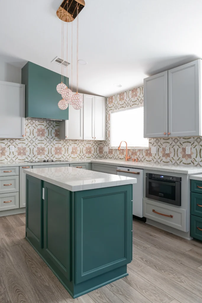 Elegant green kitchen with white island, gold accents, and playful tile backsplash.