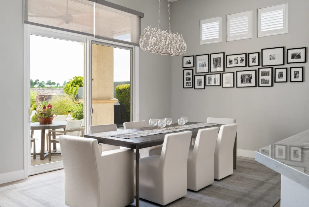 Elegant modern dining room with a sleek table, cream chairs, and stylish chandelier.