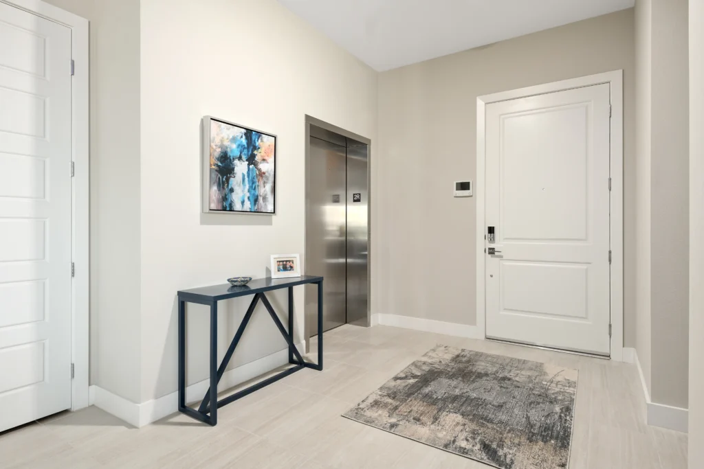 Elegant hallway with elevator and minimalist decor in The Indy Project residence.