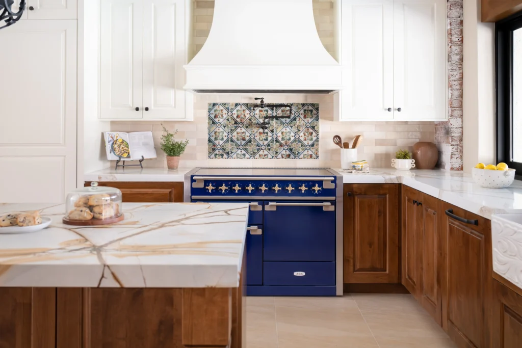 Elegant Hacienda kitchen with blue range, marble island, and warm, inviting decor.