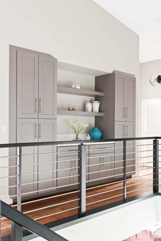 Modern light gray built-in shelving with decorative vases in a stylish interior space.