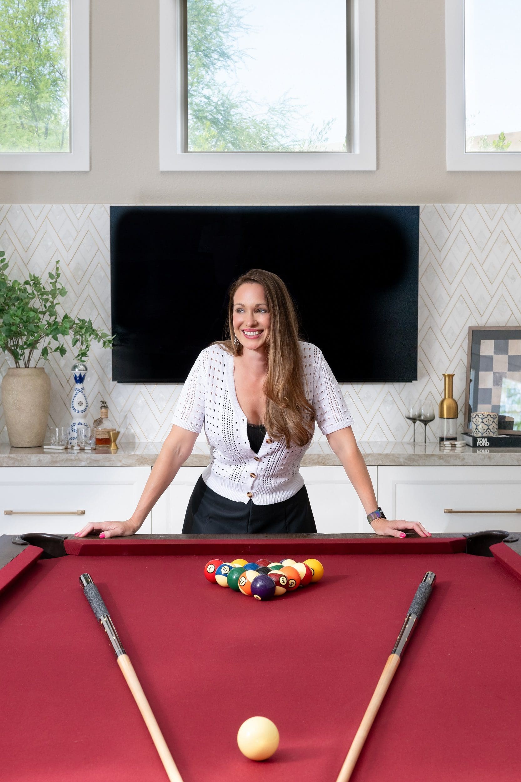 Las Vegas Reveal Interior Design owner, Kristie Schneider stands at the tables edge, radiating warmth and embodying the space’s friendly atmosphere.