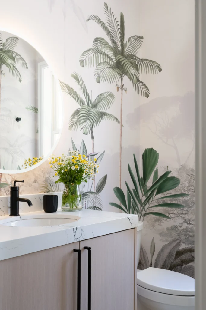 Serene tropical bathroom design with palm mural, light wood vanity, and stylish black fixtures.