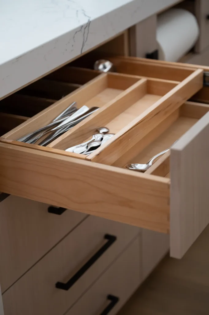 Sleek modern kitchen drawer organizer for utensils, blending functionality and style in a warm design.