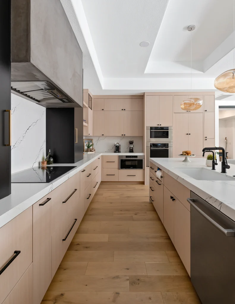 Elegant modern kitchen with light wood cabinetry, white countertops, and stylish black accents.