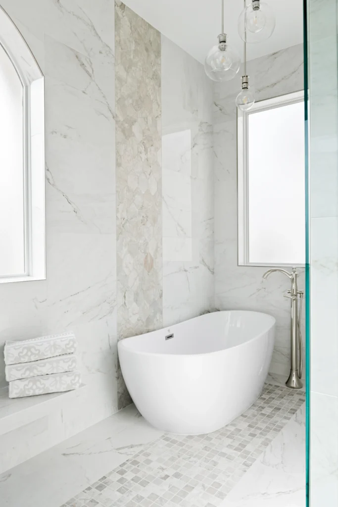 Luxurious bathroom retreat with a freestanding tub, marble tiles, and natural light.