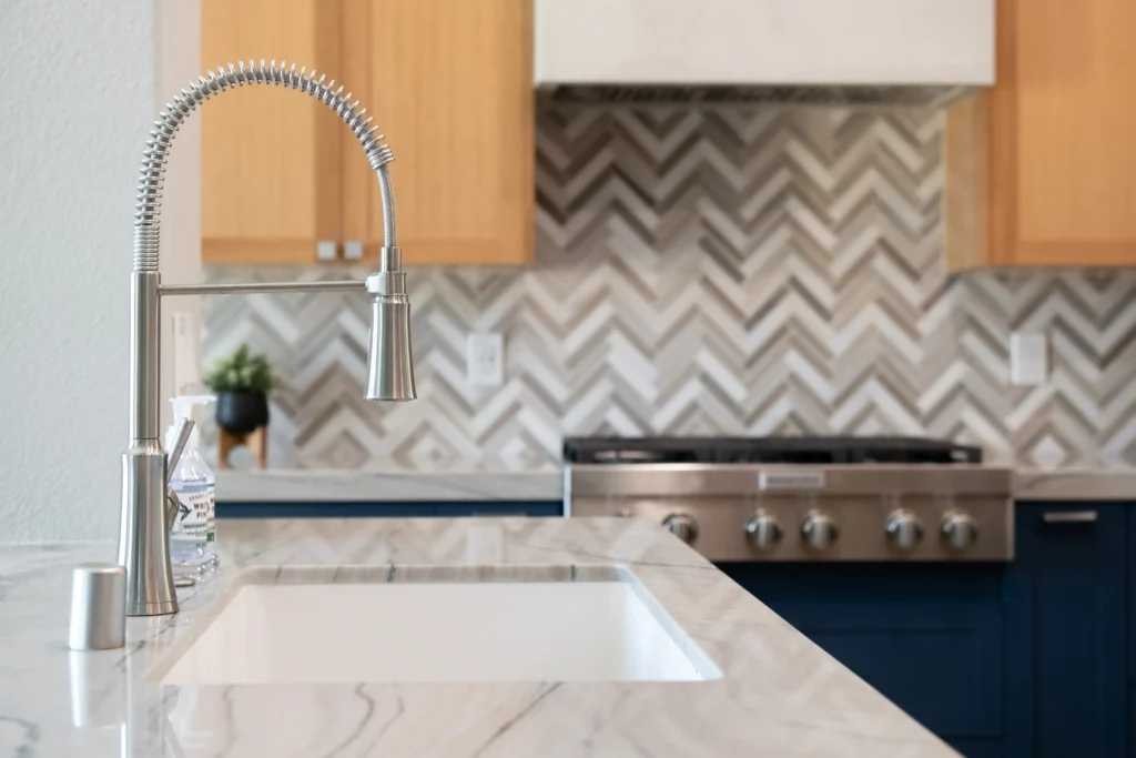 Sleek modern kitchen with stainless steel faucet, elegant sink, and stylish blue cabinetry.