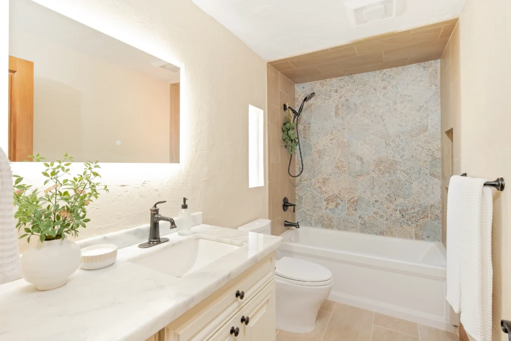 Elegant modern bathroom with beige walls, marble vanity, and stylish shower area featuring stone accents.