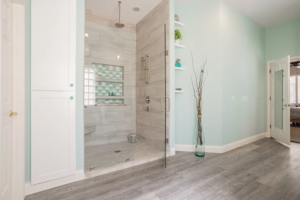 Serene mint green bathroom with glass shower, minimalist vanity, and natural decor accents.