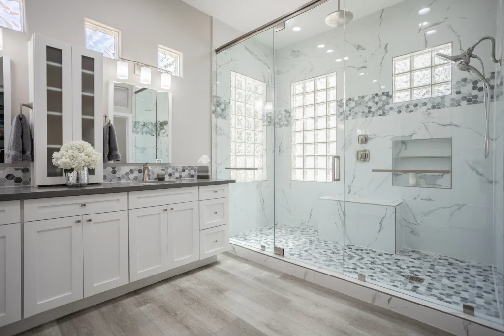 Elegant modern bathroom design featuring natural light, sleek cabinetry, and a luxurious glass shower.