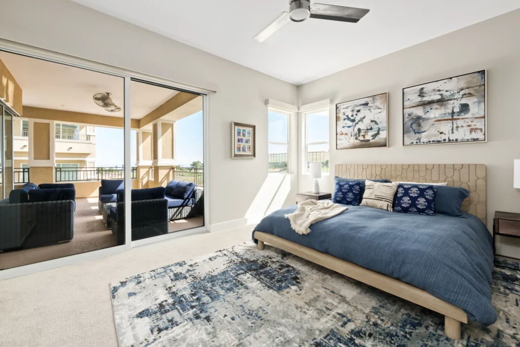 Tranquil modern bedroom with plush bedding, natural light, and stylish decor by Reveal Interior Design.