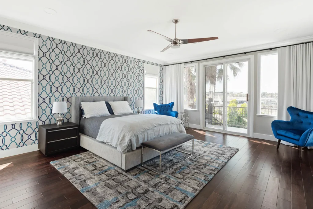 Contemporary Raven bedroom design with blue accents, natural light, and inviting hardwood finishes.