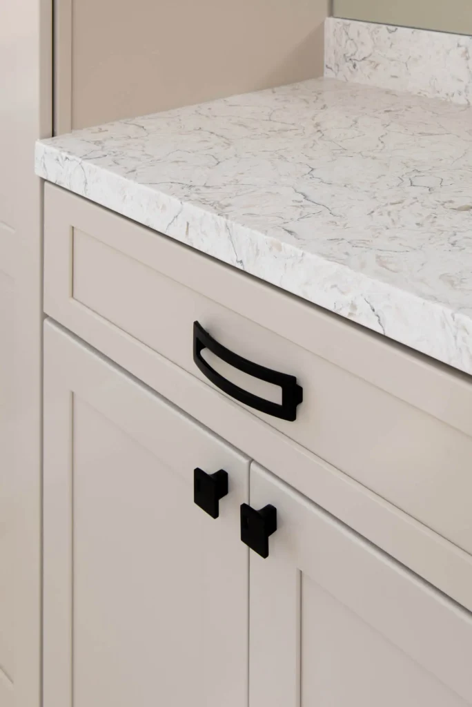 Modern cabinetry with luxurious veined countertop and sleek black accents in The Raven Project.