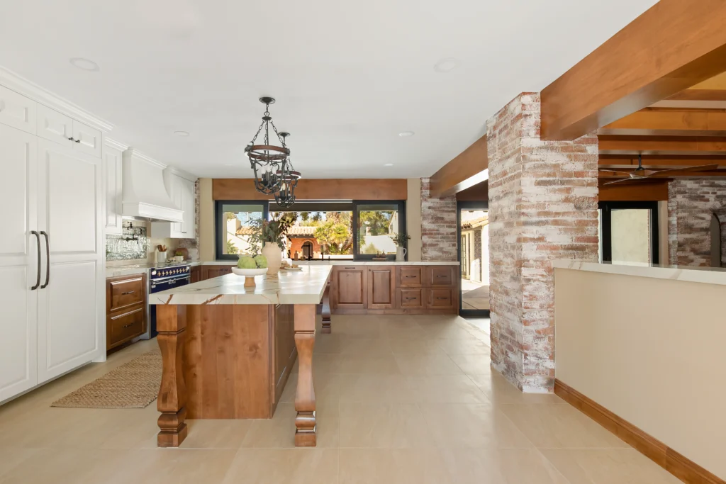 Spacious modern rustic kitchen with wood island, white cabinetry, and abundant natural light.