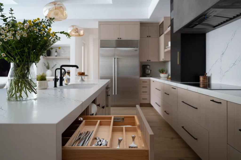 Modern kitchen design in Las Vegas featuring a spacious white island and warm beige cabinetry.