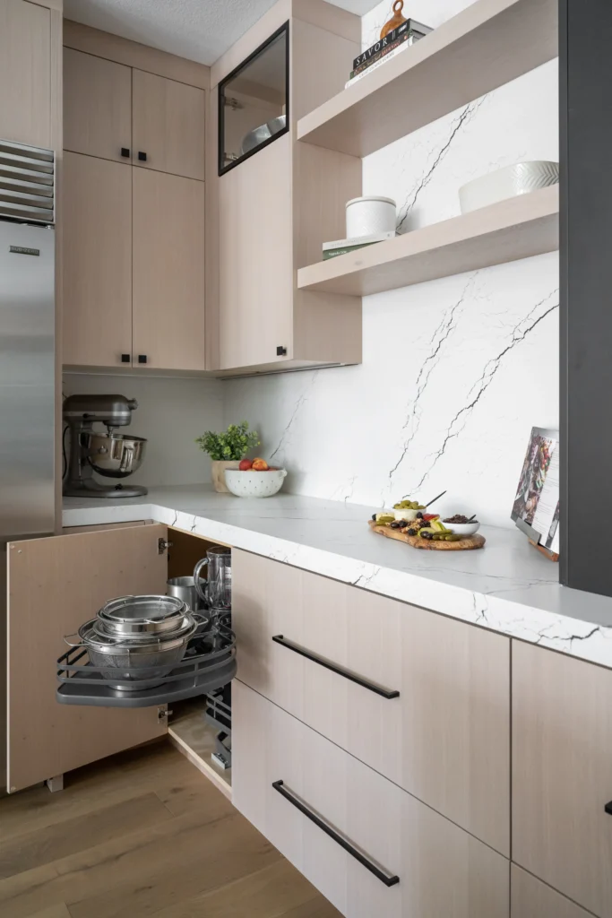 Stylish modern kitchen with light wood cabinets, elegant white countertops, and sleek appliances.