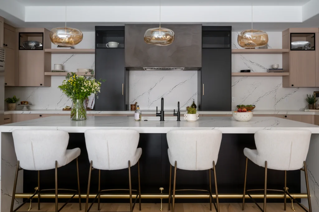 Chic modern kitchen with white island, dark cabinetry, and elegant lighting for stylish gatherings.