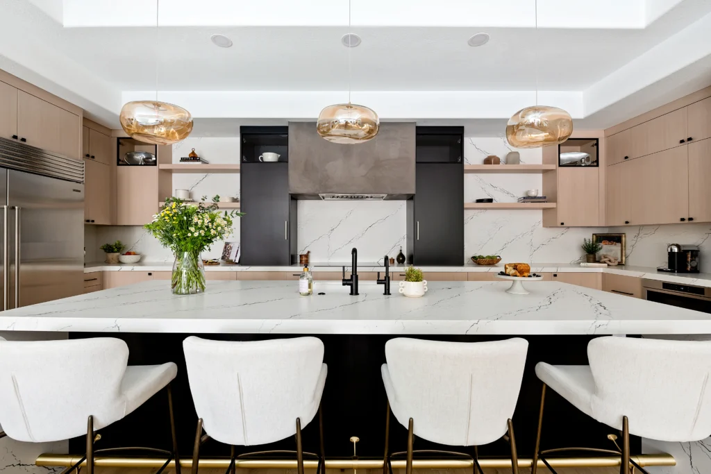 Modern kitchen with marble island, chic bar stools, and elegant cabinetry from The Lilo Project.