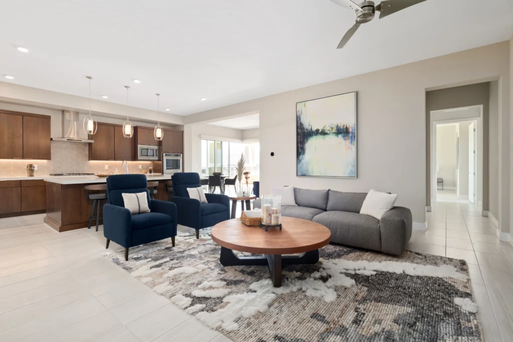 Cozy contemporary living area featuring gray sofa, navy armchairs, and modern kitchen in Las Vegas.