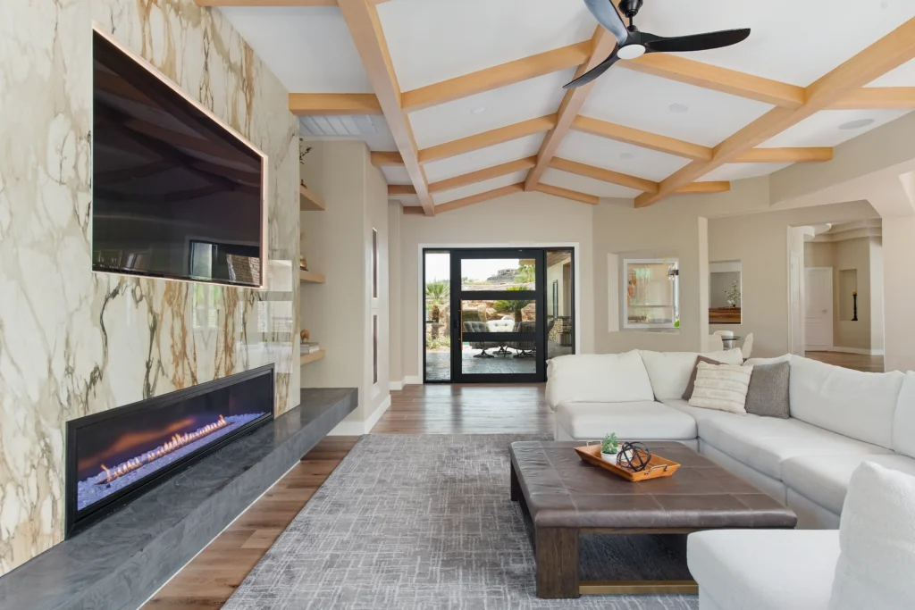 Modern living room in the Alps with marble accents and rustic wooden beams, inviting natural light.