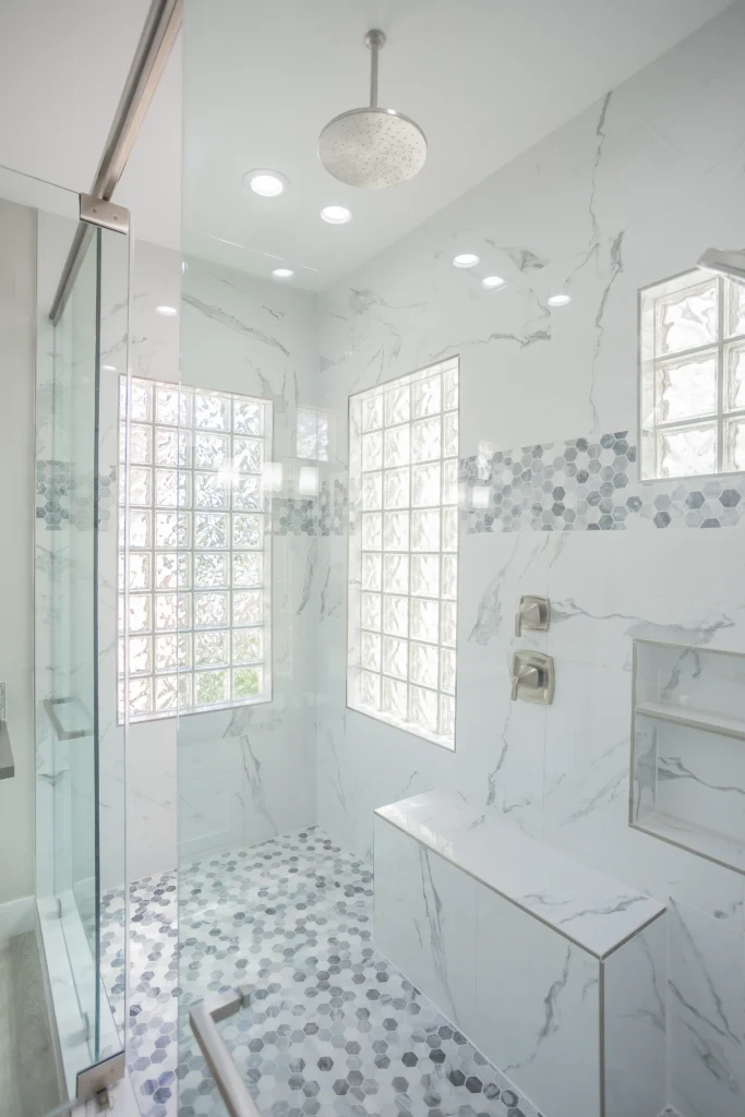 Sleek minimalist shower with elegant marble walls and soft lighting from The Waterfall Project.