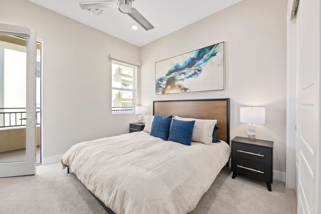 Modern bedroom with inviting decor, bright natural light, and stylish abstract artwork.