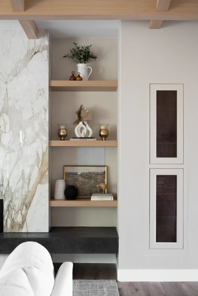 Stylish modern interior featuring marble wall, wooden shelves, and warm textures in The Alps project.