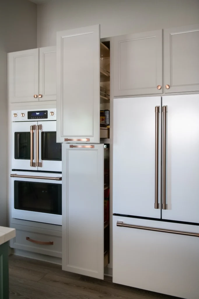 Sleek modern kitchen with elegant cabinetry, stainless-steel refrigerator, and hidden pantry for optimal organization.