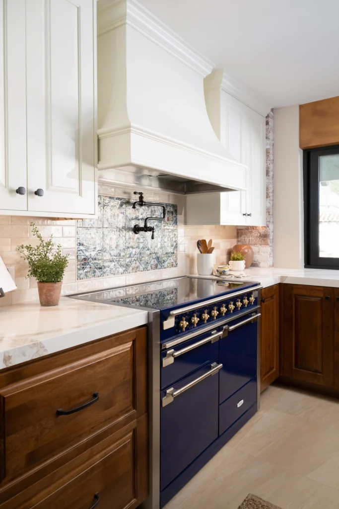 Modern and traditional blend in The Hacienda kitchen with a bold blue range and elegant design.