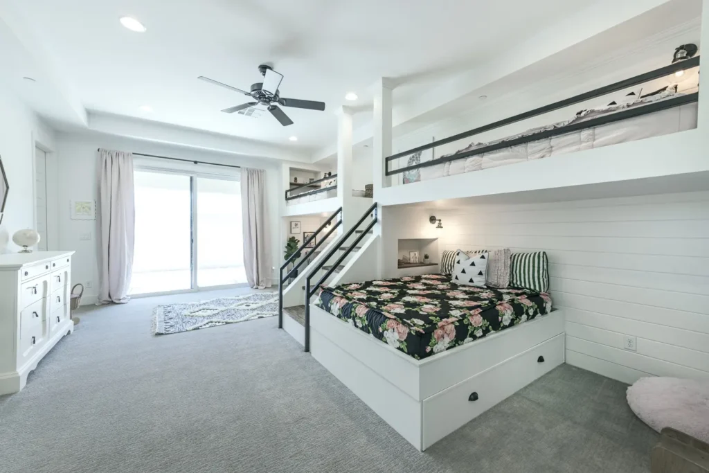 Stylish modern bedroom with vibrant bunk bed, natural light, and cozy decor.