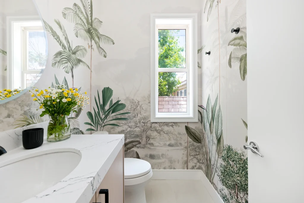 Elegant botanical bathroom with nature-inspired wallpaper, sleek vanity, and bright floral accents.