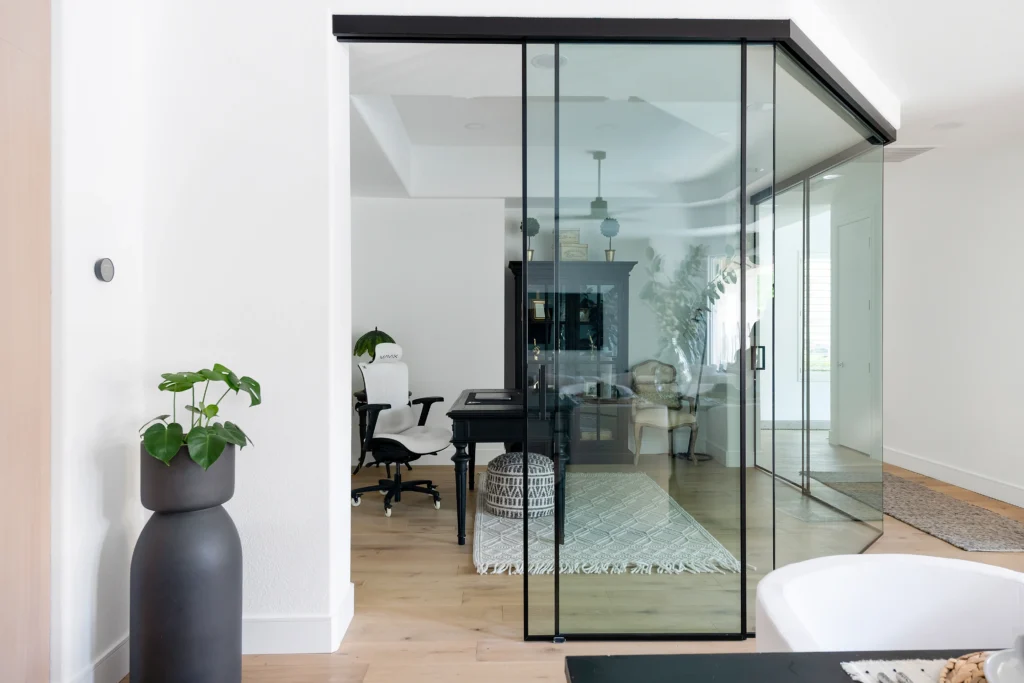 Modern office with glass walls, minimalist decor, and natural light for a productive workspace.