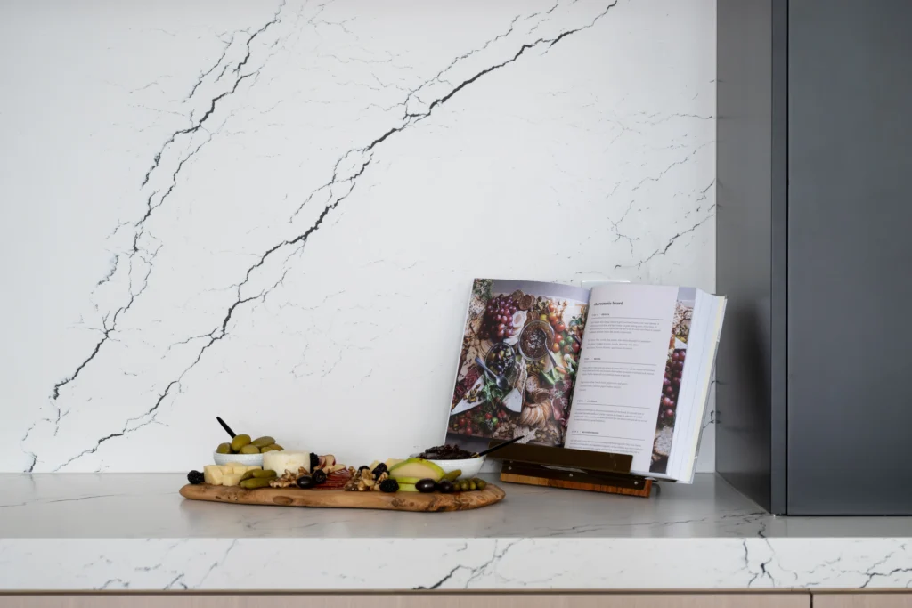 Elegant kitchen with marble countertop, fresh ingredients, and a recipe book for culinary inspiration.