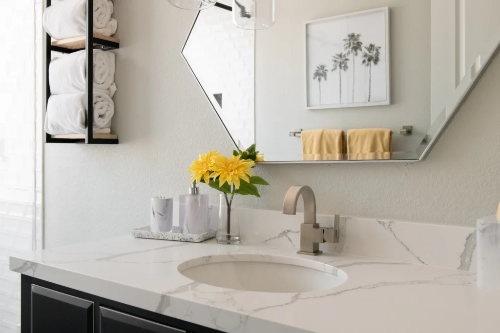 Chic modern bathroom featuring a sleek sink, stylish mirror, and vibrant yellow flower accent.