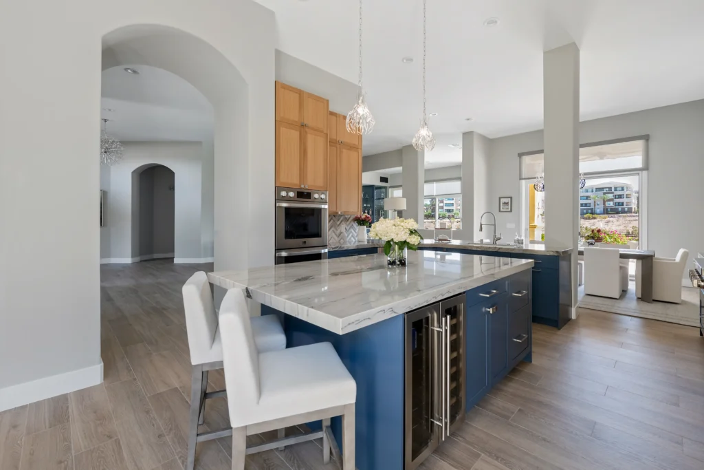 Stylish modern kitchen with blue cabinetry, light stone island, and warm wooden accents.