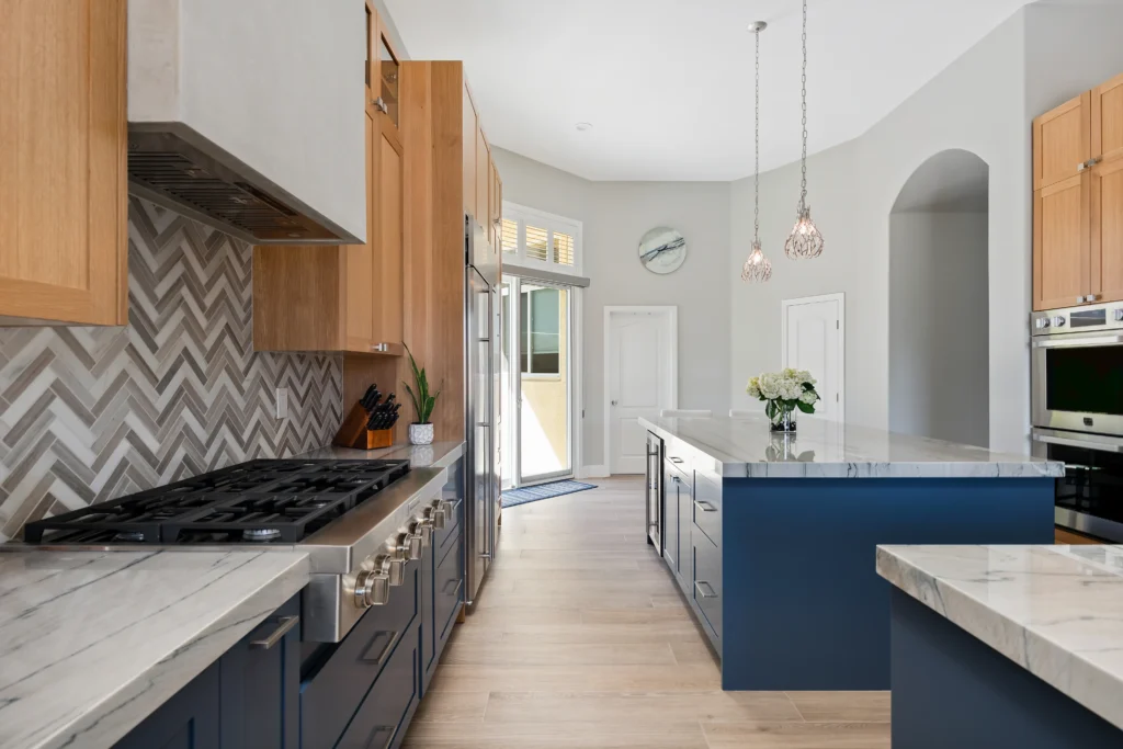 Elegant modern kitchen in Las Vegas with navy cabinetry, light stone countertops, and abundant natural light.