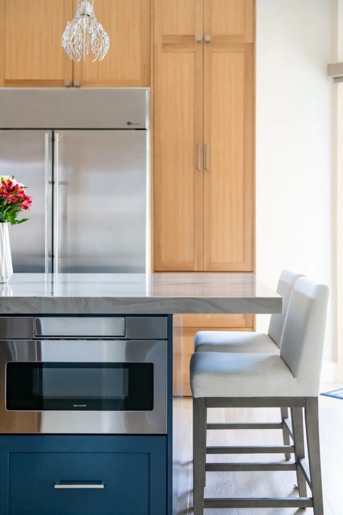 Sleek modern kitchen with navy island, stainless steel appliances, and inviting barstools for gatherings.