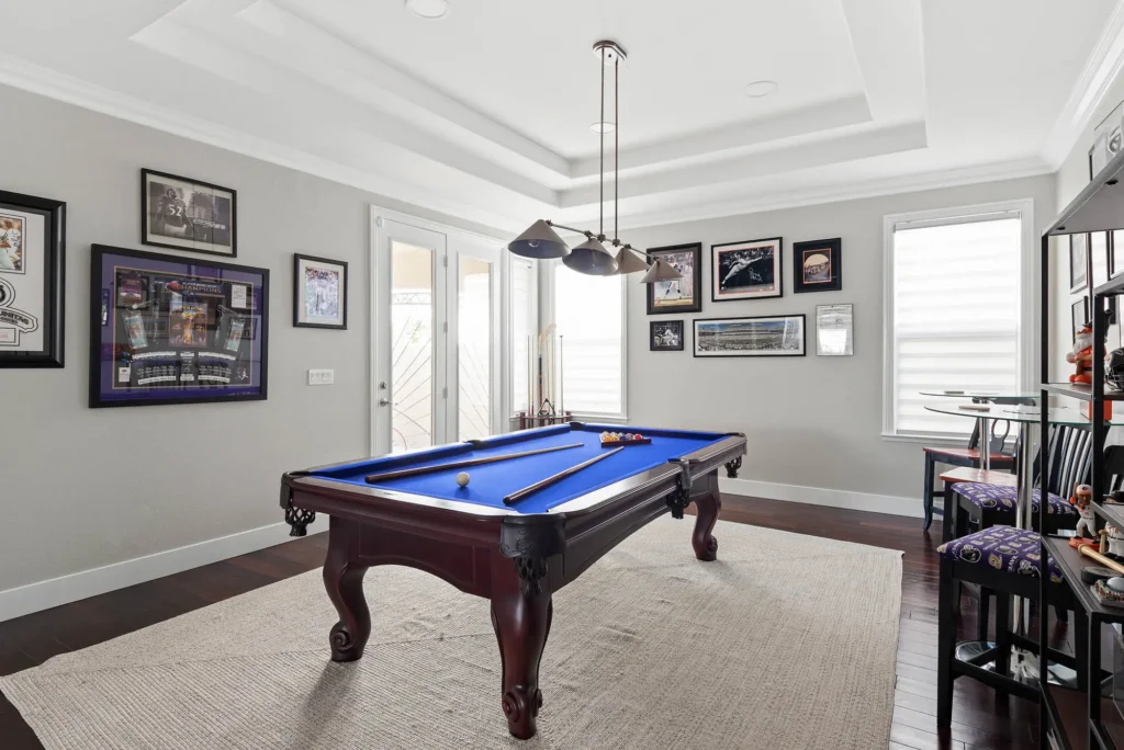 Stylish billiard room with a classic pool table, cozy seating, and vibrant decor.