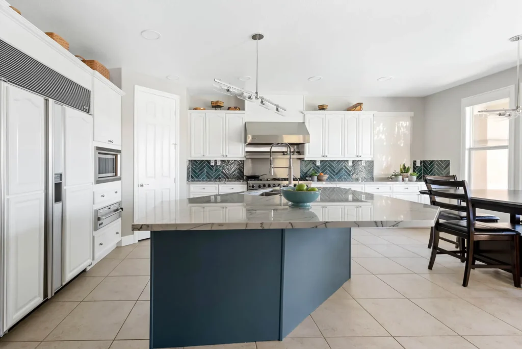 Sleek minimalist kitchen with blue island, stylish backsplash, and modern appliances for functional living.