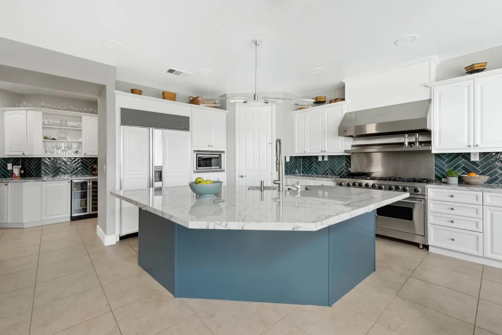 Modern kitchen design featuring a striking marble island, white cabinetry, and abundant natural light.