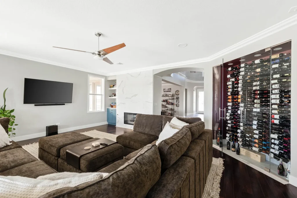 Stylish modern living room with a sectional sofa, TV, and elegant wine storage.