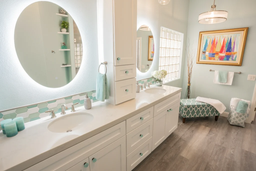 Bright beach-inspired bathroom with soft blue hues, sleek double vanity, and cozy seating area.