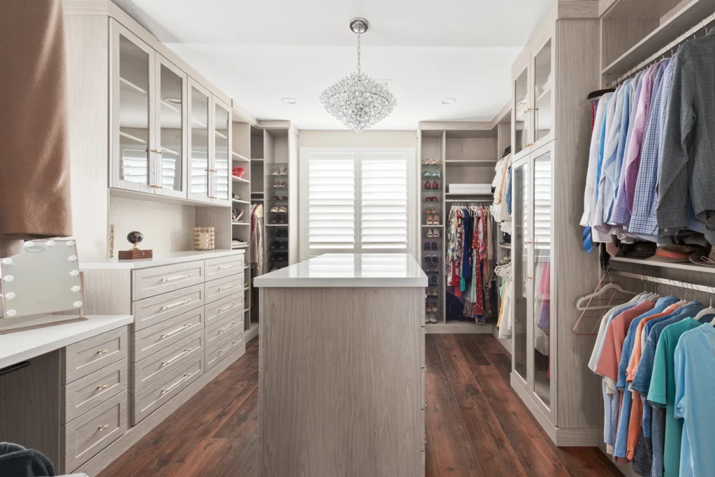 Elegant walk-in closet with organized shelving, a functional island, and bright natural light.